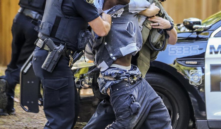 Marietta Police arrest a man they say holed up inside a Marietta, Ga., home after trying to steal a truck from a nearby home Wednesday, Oct. 25, 2017. Chuck McPhilamy, spokesman with Marietta police, said the man, who they haven't identified, "talked his way into a home" on Springhollow Lane, just off Powder Springs Street Southwest and Bellemeade Drive Southwest. A negotiator with the Marietta police SWAT team was able to get the man out of the home without incident, the spokesman said. (John Spink/Atlanta Journal-Constitution via AP)