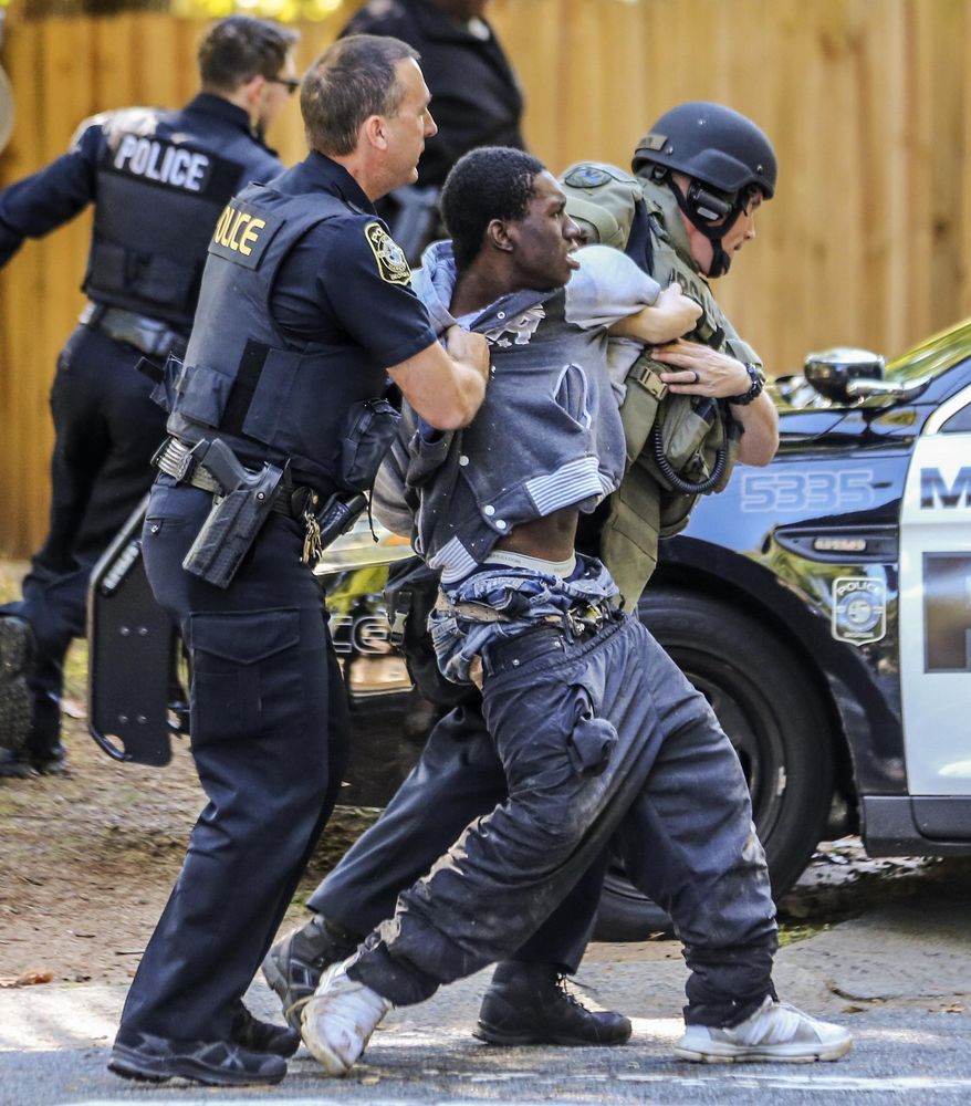Marietta Police arrest a man they say holed up inside a Marietta, Ga., home after trying to steal a truck from a nearby home Wednesday, Oct. 25, 2017. Chuck McPhilamy, spokesman with Marietta police, said the man, who they haven't identified, "talked his way into a home" on Springhollow Lane, just off Powder Springs Street Southwest and Bellemeade Drive Southwest. A negotiator with the Marietta police SWAT team was able to get the man out of the home without incident, the spokesman said. (John Spink/Atlanta Journal-Constitution via AP)