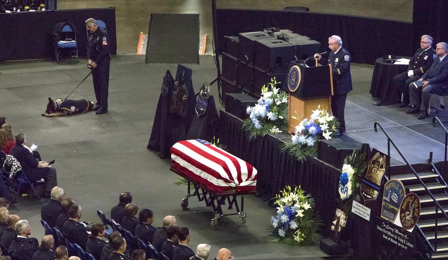 In this photo provided by WBFO News, the casket of Buffalo Police Officer Craig Lehner is positioned in front of the state at Key Bank Center, during Lehner's funeral in Buffalo, N.Y., Wednesday, Oct. 25, 2017. Lehner was killed in a training dive accident in the Niagara River on Oct. 13. At top left is his canine partner Shield. (Eileen Koteras Elibol/WBFO News via AP)