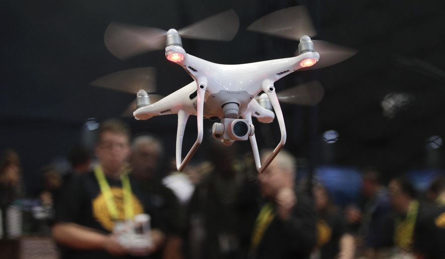 FILE - In this Jan. 5, 2017 file photo, an exhibitor demonstrates a drone flight at CES International, in Las Vegas. White House officials said Trump will sign a memorandum Wednesday permitting states, localities and tribes to craft their own pilot programs to test drones. There is no limit on the number of communities that can participate. (AP Photo/Jae C. Hong)