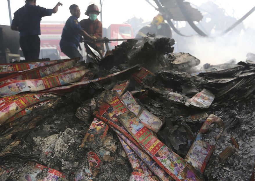 Firefighters work at the site of an explosion at a firecracker factory in Tangerang, on the outskirt of Jakarta, Indonesia, Thursday, Oct. 26, 2017. The explosion and raging fire killed a number of people and injured dozens, police said. (AP Photo/Tatan Syuflana)