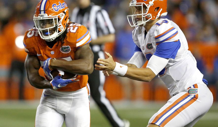 FILE - In this April 17, 2017, file photo, Florida running back Jordan Scarlett (25) takes the handoff from quarterback Feleipe Franks (13) during an spring NCAA college football game in Gainesville, Fla. Seven suspended Florida players, including Callaway, are entering a pretrial intervention program that could result in the dismissal of felony credit card fraud charges. (Brad McClenny/The Gainesville Sun via AP, File)
