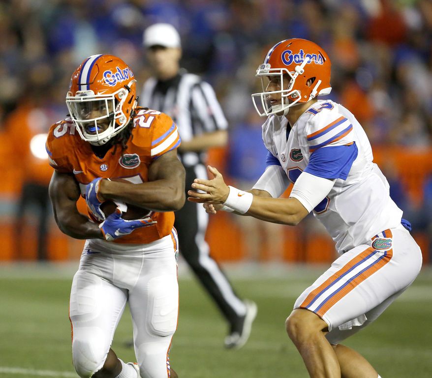 FILE - In this April 17, 2017, file photo, Florida running back Jordan Scarlett (25) takes the handoff from quarterback Feleipe Franks (13) during an spring NCAA college football game in Gainesville, Fla. Seven suspended Florida players, including Callaway, are entering a pretrial intervention program that could result in the dismissal of felony credit card fraud charges. (Brad McClenny/The Gainesville Sun via AP, File)