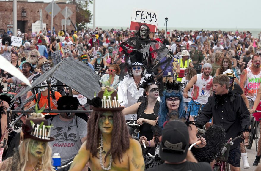 In this Sunday, Oct. 22, 2017, photo provided by the Florida Keys News Bureau, thousands of people participate in the Fantasy Fest Zombie Bike Ride in Key West, Fla. The ride was one of the many events set for the island city's 10-day Fantasy Fest costuming and masking celebration that continues through Sunday, Oct. 29. (Rob O'Neal/Florida Keys News Bureau via AP)