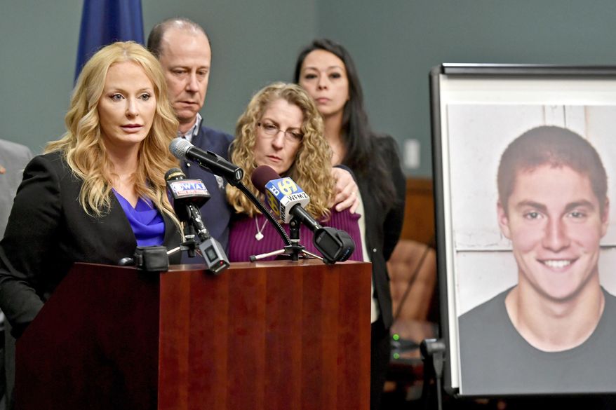 FILE – In this May 5, 2017, file photo, Centre County, Pa., District Attorney Stacy Parks Miller, left, announces findings an investigation into the death of Penn State University fraternity pledge Tim Piazza, seen in photo at right, as his parents, Jim and Evelyn Piazza, second and third from left, stand nearby during a news conference in Bellefonte, Pa. Parks Miller reinstated certain charges against members of Penn State's former Beta Theta Pi fraternity Friday, Oct. 27, 2017, nearly two months after a district judge dismissed the most serious charges of involuntary manslaughter and aggravated assault originally filed by prosecutors in response to the Feb. 4, 2017, death of 19-year-old Tim Piazza, of Lebanon, N.J., after a night of heavy drinking. (Abby Drey/Centre Daily Times via AP, File)
