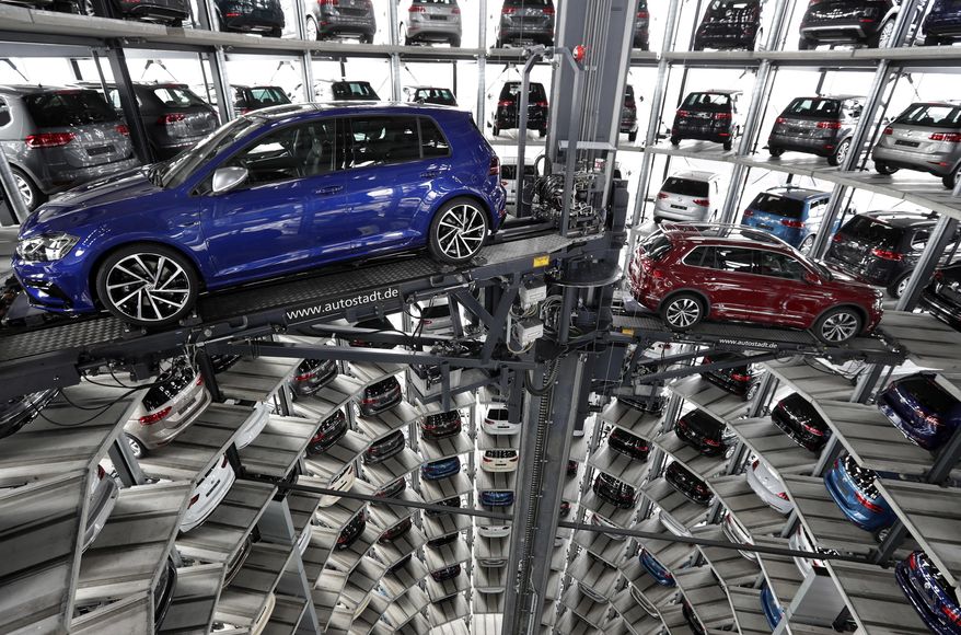 FILE - In this March 14, 2017 file photo Volkswagen cars are lifted inside a delivery tower of the company in Wolfsburg, Germany. Automaker Volkswagen saw profit drop by half in the third quarter due to expenses for fixing and buying back diesel cars in the United States. The Wolfsburg-based automaker said Friday, Oct. 27, 2017, that it was otherwise a “strong third quarter” and raised its earnings outlook for the full year. (AP Photo/Michael Sohn, file)
