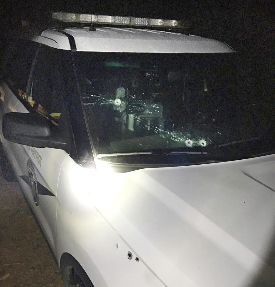 This Oct. 24, 2017, photo released by the Washington State Patrol shows a trooper's cruiser with bullet holes following a shootout with two men in Grandview, Wash., late on Oct. 23, 2017. The State Patrol is looking for two people among the vineyards of south-central Washington after they opened fire on a trooper who tried to pull them over for speeding. (Chris Thorson/Washington State Patrol via AP)