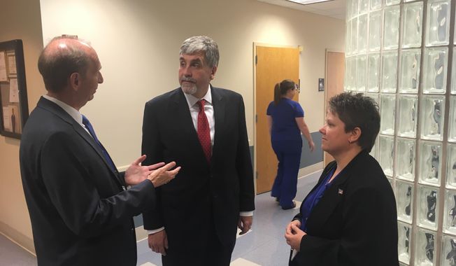 Acting Health and Human Services Secretary Eric Hargan, center, speaks with University of Kentucky HealthCare Vice President Mark Birdwhistell, left, and project manager Beth Snider, right, at the Polk-Dalton Clinic on Friday, Oct. 27, 2017, in Lexington, Kentucky. Hargan toured the facility one day after signing an order declaring the opioid crisis a public health emergency. The clinic includes a program that provides drug treatment to pregnant women and their children who are addicted to opioid-based drugs. (AP Photo/Adam Beam)