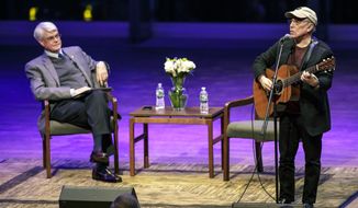 In this Oct. 26, 2017 photo provided by Skidmore College, Grammy winning recording artist Paul Simon performs a song at Skidmore College in Saratoga Springs, N.Y. The singer-songwriter visited the college to participate in a master class about songwriting, followed by an event titled &amp;quot;Paul Simon: A Conversation about a Musical Life.&amp;quot; At left is Skidmore President Philip A. Glotzbach. (Christopher Massa/Skidmore College via AP)