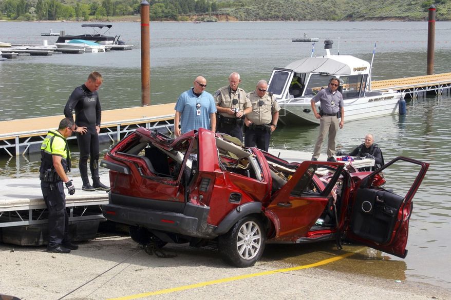 FILE - This June 2, 2016 file photo photo provided by the Ada County Sheriff's Office, deputies and the Boise Fire Department dive team stand by the wreckage of an SUV driven by a 40-year-old Boise woman that plunged off a cliff into the Lucky Peak Reservoir in Boise, Idaho. Authorities said Friday, Oct. 27, 2017 that Noel Bankhead deliberately drove her sport-utility vehicle off a cliff and into a reservoir in a crash that killed her and her three young children. The Ada County Coroner's Office ruled the deaths that occurred a triple homicide-suicide. (Patrick Orr/Ada County Sheriff's Office via AP, File)
