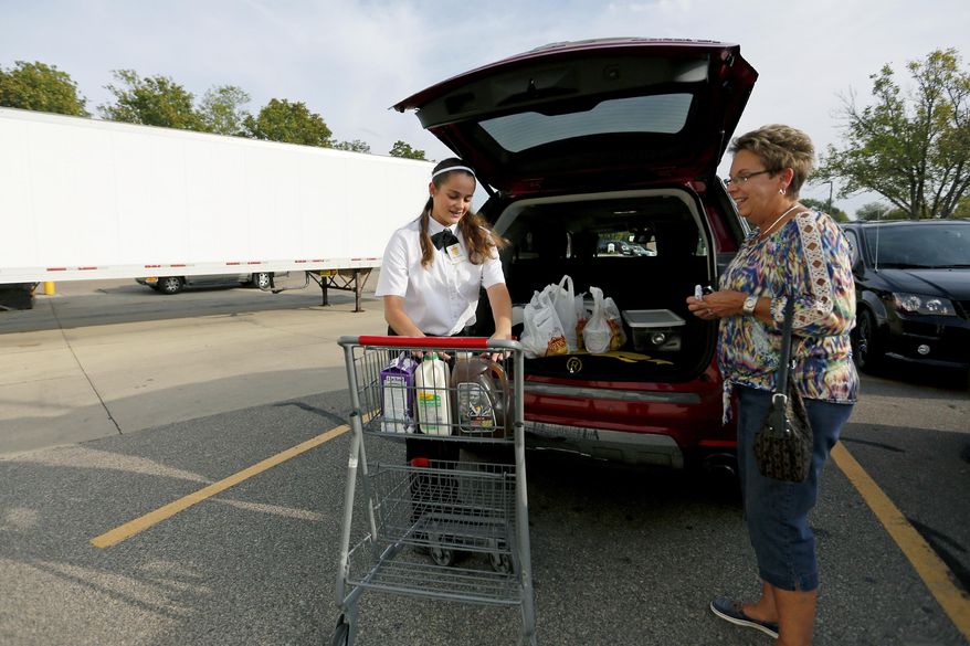 In this Monday, Oct. 2, 2017, photo, Ava Terwilleger, left, 14, of Dubuque, Iowa, helps Kathy Kearney with her groceries at Fareway in Dubuque, Iowa. (Eileen Meslar/Telegraph Herald via AP)