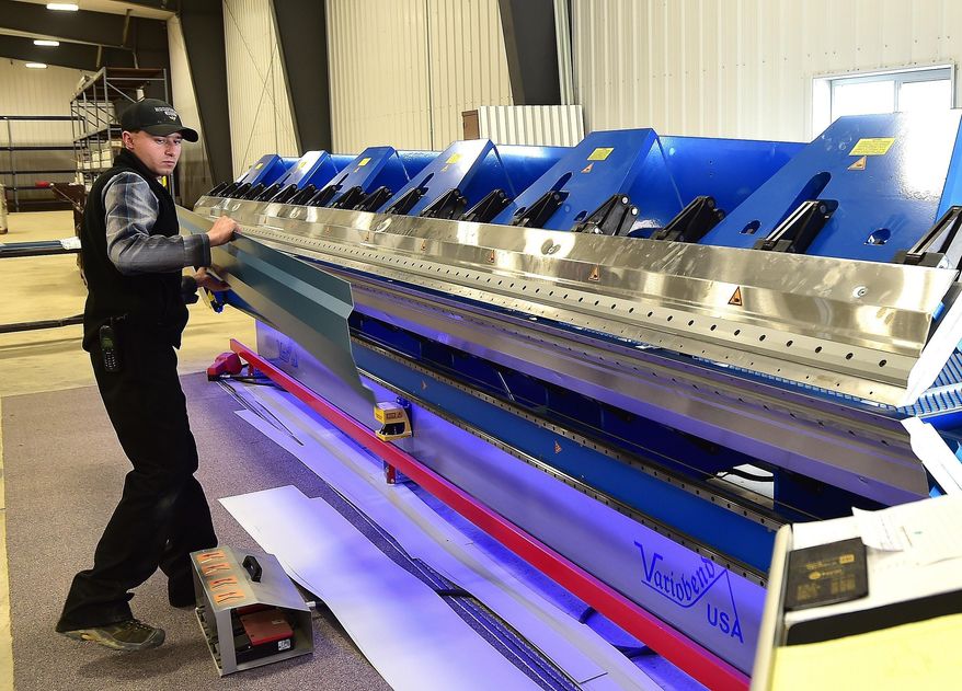 In this Oct. 10, 2017 photo, Josh Kleinsasser checks a processed piece of steel as the Golden Valley Hutterite Colony opens Valley Steel, LLC near Ryegate, Mont. The new venture builds custom steel siding and roofing products. (Larry Mayer /The Billings Gazette via AP)