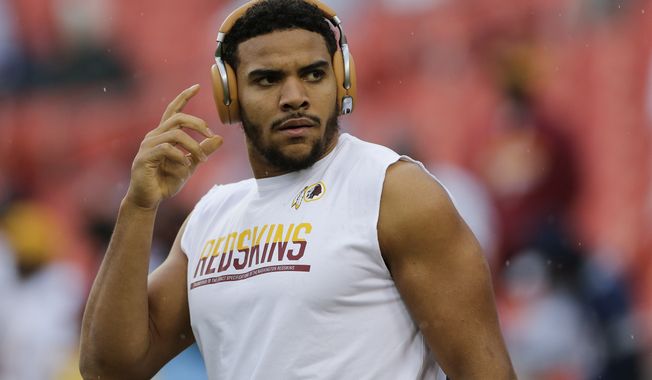 Washington Redskins tight end Jordan Reed (86) reaches for his headphones during the warm up period before an NFL football game against the Dallas Cowboys in Landover, Md., Sunday, Oct. 29, 2017. (AP Photo/Mark Tenally)