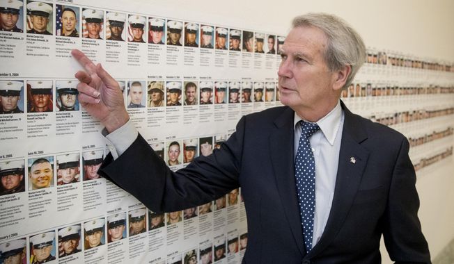 In this Oct. 25, 2017, photo, Rep. Walter Jones, R-N.C. points at a photograph of Marine Sgt. Michael Edward Bits of Ventura, Calif., the first military funeral he and his wife attended, and one of the many pictures of soldiers killed this century based in Camp Lejeune along a hallway leading to his office on Capitol Hill in Washington. As President Trump argued about what he said to the family of a soldier killed in Niger, a North Carolina congressman was quietly doing what he&#x27;s done more than 11,000 times: signing a condolence letter to that family and others. Republican Rep. Walter Jones began signing the letters to families in 2003 as penance for his 2002 vote supporting war in Iraq. (AP Photo/Andrew Harnik)