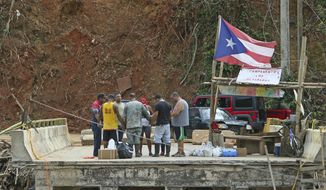 In this Friday, Oct. 27, 2017 photo, good samaritans of the town of Isabela make a circle of prayer with the residents of Rio Abajo in Utuado as recovery efforts from Hurricane Maria continue in Puerto Rico. (David Santiago/Miami Herald via AP)