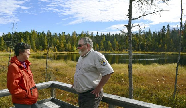 In this Oct. 11, 2017, photo, U.S. Fish and Wildlife Service&#x27;s Andrew French, right, talks with The Nature Conservancy&#x27;s Kim Lutz, who also is the chairman of the Friends of the Silvio O. Conte National Fish &amp;amp; Wildlife Refuge, along the Mud Pond Trail in the refuge near Jefferson, N.H. Both support a plan proposed by the U.S. Fish and Wildlife Service that calls for greatly expanding the national refuge which covers parts of the Connecticut River watershed in four New England states. (AP Photo/Michael Casey)