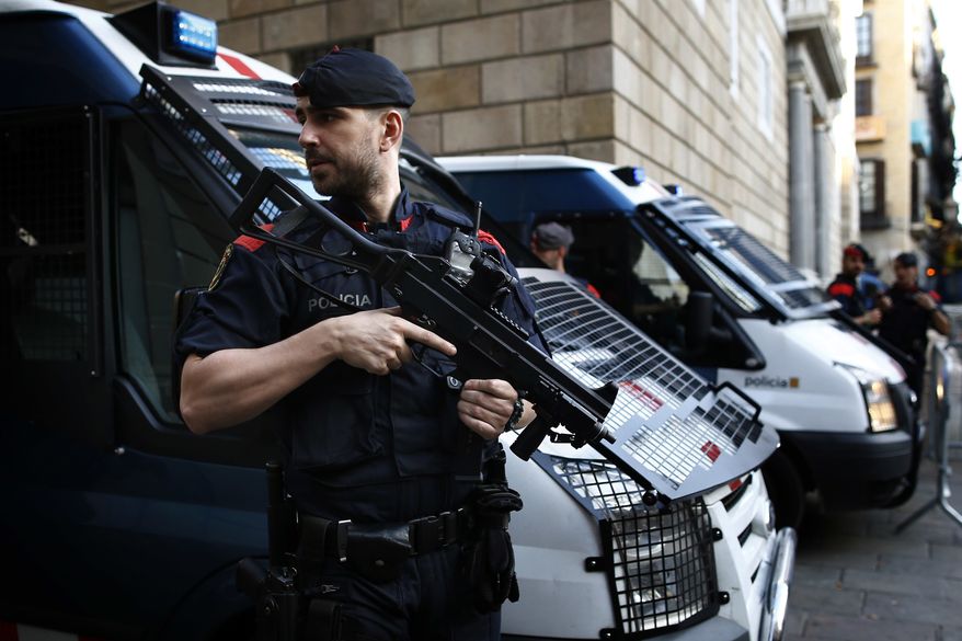 Catalan police officers stand guard next to the Palau Generalitat in Barcelona, Spain, Monday Oct. 30, 2017. Catalonia's civil servants face their first full work week since Spain's central government overturned an independence declaration by firing the region's elected leaders. (AP Photo/Manu Fernandez)