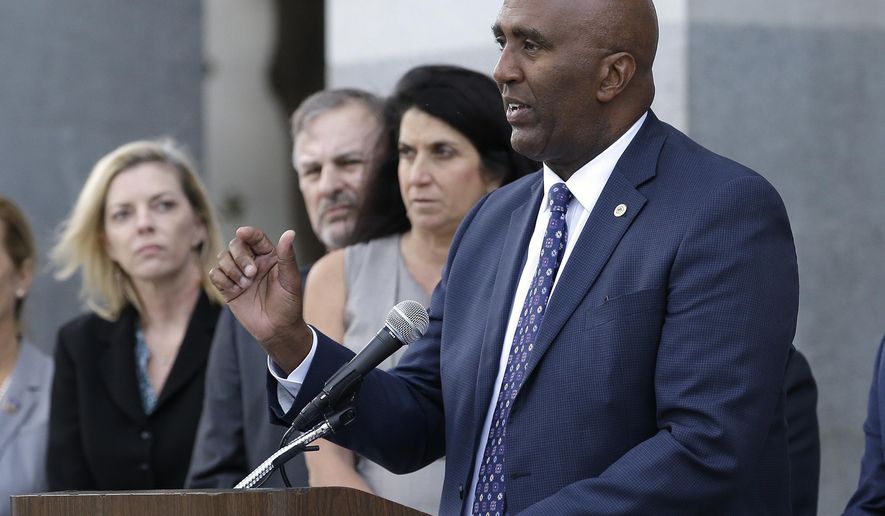 Assemblyman Jim Cooper, D-Elk Grove, right, outlines his proposed ballot initiative that would bar certain connected rapists and sex traffickers from earning credits to reduce their sentences, during a news conference, Monday, Oct. 30, 2017, in Sacramento, Calif. The initiative needs 365,880 signatures to be placed before voters in the 2018 general election. (AP Photo/Rich Pedroncelli)