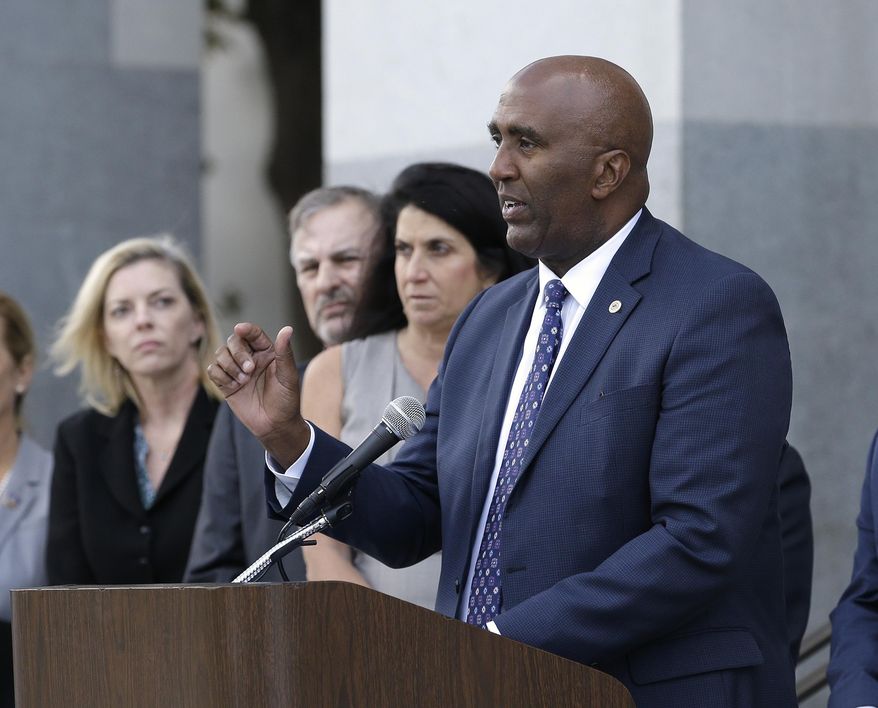 Assemblyman Jim Cooper, D-Elk Grove, right, outlines his proposed ballot initiative that would bar certain connected rapists and sex traffickers from earning credits to reduce their sentences, during a news conference, Monday, Oct. 30, 2017, in Sacramento, Calif. The initiative needs 365,880 signatures to be placed before voters in the 2018 general election. (AP Photo/Rich Pedroncelli)