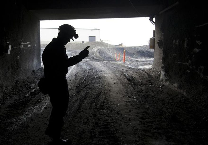 FILE - In this Nov. 9, 2010, file photo, a mine employee stands in the entry of the Signal Peak Energy's Bull Mountain mine in Roundup, Mont. Attorneys for the coal mine are due in court this week to press a judge to reverse an order they say would prompt dozens of layoffs by blocking the mine's expansion plans. U.S. District Judge Donald Molloy scheduled a Tuesday, Oct. 31, 2017 hearing in Missoula in the case involving the mine. (AP Photo/Janie Osborne,File)