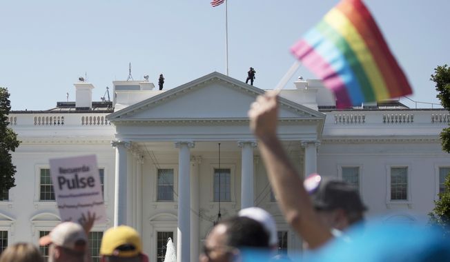 Equality March for Unity and Pride participants march past the White House in Washington. A federal court in Washington is barring President Donald Trump from changing the government&#x27;s policy on military service by transgender people.  (AP Photo/Carolyn Kaster)