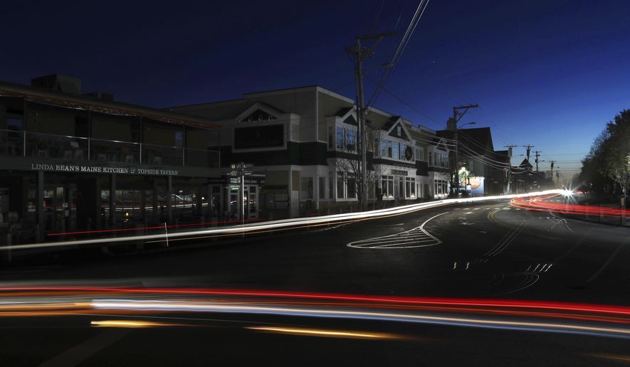 Lights from automobile traffic leave trails on a street in Freeport, Maine, where most outlet shopping stores are closed due to a severe storm knocked out electricity, Monday, Oct. 30, 2017. The severe storm packing hurricane-force wind gusts and soaking rain swept through the Northeast early Monday, knocking out power for nearly 1.5 million homes and businesses and forcing hundreds of schools to close in New England. (AP Photo/Robert F. Bukaty)