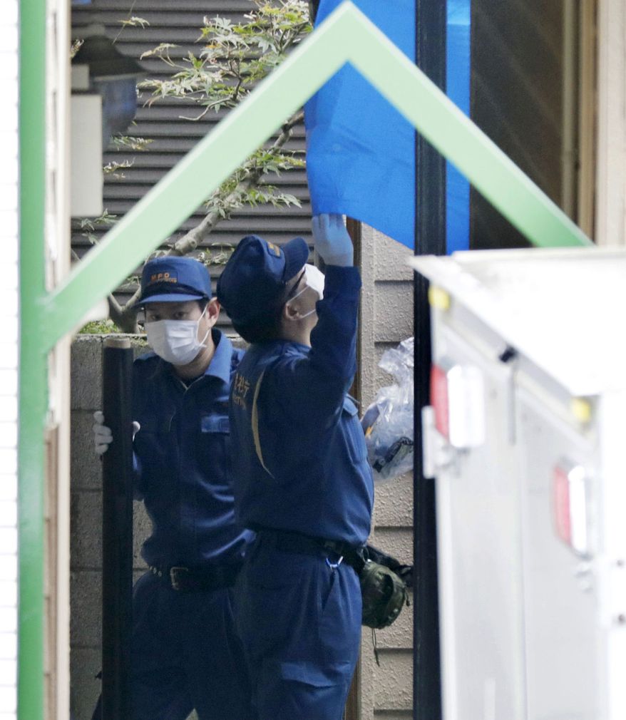 Police inspect the apartment where dismembered bodies were found in coolers in Zama city, southwest of Tokyo, Tuesday, Oct. 31, 2017. A police spokesman said Tuesday the 27-year-old suspect confessed to cutting up the bodies and hiding them in cold-storage cases, covered with cat litter. (Shin Kigeuchi/Kyodo News via AP)