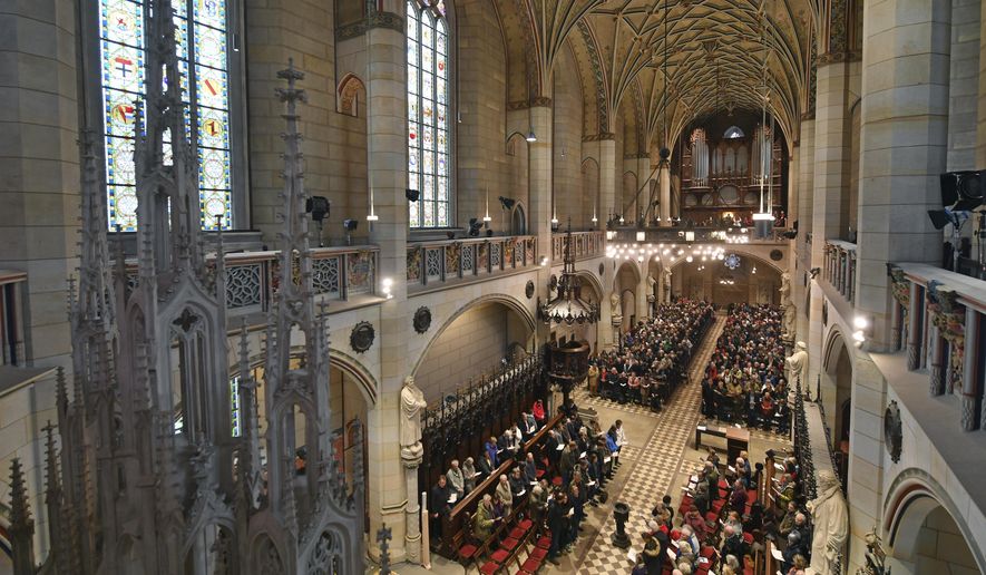 Visitors of the service sit in the All Saints' Church or Castle Church in Wittenberg, Germany, Tuesday Oct. 31, 2017. German leaders will mark the 500th anniversary of the day Martin Luther is said to have nailed his theses challenging the Catholic Church's practice of selling indulgences to a church door, a starting point of the Reformation. (Hendrik Schmidt/dpa via AP)