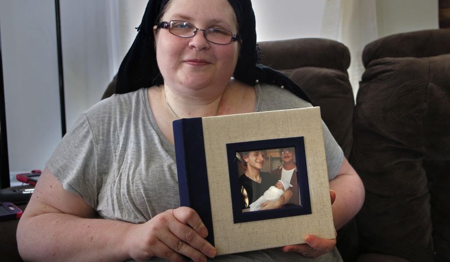 In this Friday, Oct. 20, 2017, photo, Bethany Miller poses for a photo as she holds a photo album with her late son Kyle Wilson and his daughter on the cover in Jay, Maine. Miller said her son, who died from a diabetic coma, would've been among those in Maine who could benefit if voters on Nov. 7 demand a Medicaid expansion. "He had a job, but he didn’t make enough money to pay for his basic needs and his insulin, and he couldn't live without his insulin," said Miller. (AP Photo/Robert F. Bukaty)