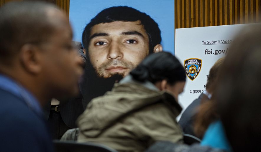 A photo of Sayfullo Saipov is displayed at a news conference at One Police Plaza Wednesday, Nov. 1, 2017, in New York.  Saipov is accused of driving a truck on a bike path that killed several and injured others Tuesday near One World Trade Center.  (AP Photo/Craig Ruttle)