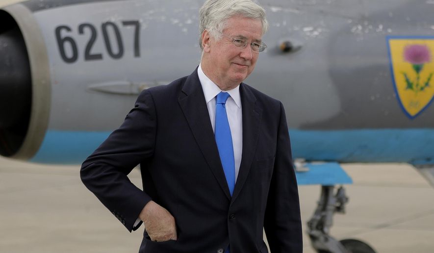 FILE - A Wednesday, June 14, 2017 file photo of Britain's Defense Minister Michael Fallon walking next to a Soviet era built MIG21 jet fighter at the Mihail Kogalniceanu air base, Romania. The UK government said Wednesday, Nov. 1, 2017 that Defense Secretary Michael Fallon has resigned after allegations of inappropriate behavior. (AP Photo/Vadim Ghirda, File)