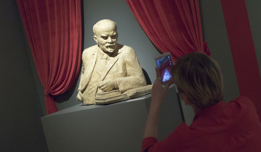 A woman photographs the sculpture of Soviet founder Vladimir Lenin during the opening of &quot;Energy of the Dream. entennial of 1917 revolution&quot; exhibition in Moscow, Russia, on Thursday, Nov. 2, 2017. Russia will mark 100th anniversary of 1917 Bolshevik revolution on Nov. 7, 2017. (AP Photo/Ivan Sekretarev)