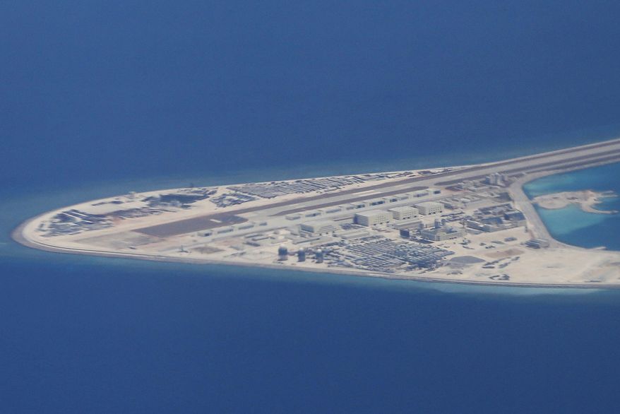 FILE - In this April 21, 2017, file photo, an airstrip, structures and buildings on China's man-made Subi Reef in the Spratly chain of islands in the South China Sea are seen from a Philippine Air Force C-130 transport plane of the Philippine Air Force. Security and trade will loom large during President Donald Trumps first official visit to Asia, which gets underway Sunday, Nov. 5, 2017, in Japan. Among the world's busiest sealanes, the disputed South China Sea is one of the Asian troublespots, where Trump can showcase American leadership and commitment to the region and edgy allies in a high-profile way. It can also explicitly mirror the lack of it. (AP Photo/Bullit Marquez, File)