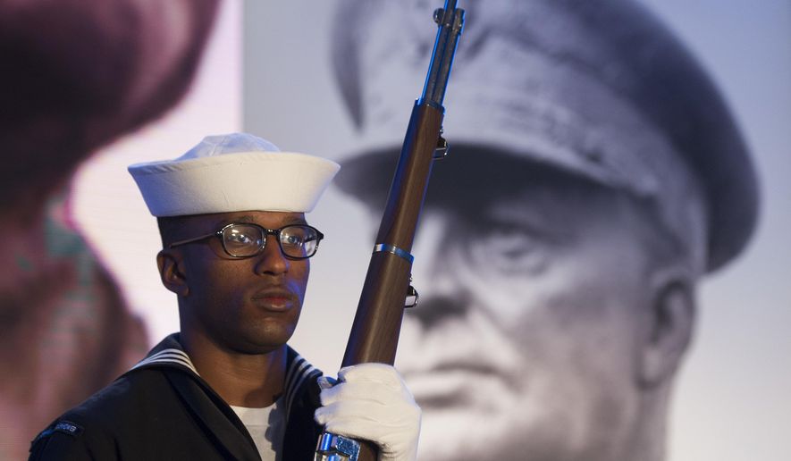 A Navy sailor and member of an honor guard stands in front of a photograph of Gen. Dwight D. Eisenhower during the groundbreaking at the site of the Dwight D. Eisenhower Memorial, in Washington, Thursday, Nov. 2, 2017. (AP Photo/Cliff Owen)