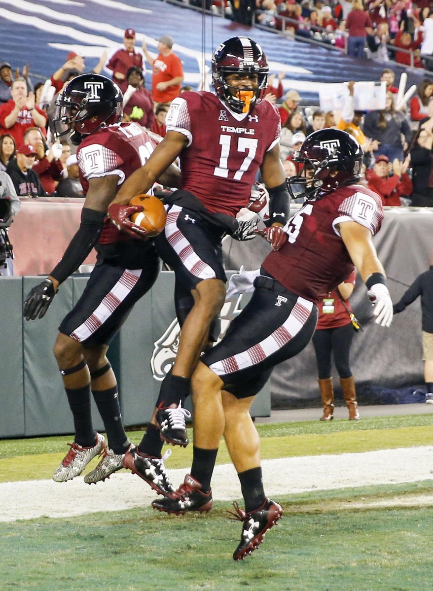 Temple wide receiver Adonis Jennings, center, celebrates his first-quarter touchdown reception against Navy with wide receiver Randle Jones, left, and fullback Rob Ritrovato during an NCAA college football game Thursday, Nov. 2, 2017, in Philadelphia. (Yong Kim/The Philadelphia Inquirer via AP)