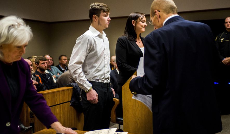 Trevor Gray, center, one of five defendants being charged as an adult, listens Thursday, Nov. 2, 2017, in Genesee District Court, in downtown Flint, Mich., as Genesee District Judge William H. Crawford approves motions for competency evaluations for three of the five teenagers, who face charges of second-degree murder after Kenneth White was killed when a large rock was thrown from an overpass and smashed through the vehicle he was riding in. The five defendants range in age from 15 to 18. (Jake May /The Flint Journal-MLive.com via AP)