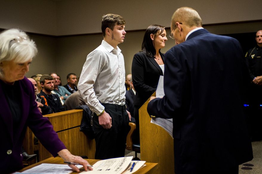 Trevor Gray, center, one of five defendants being charged as an adult, listens Thursday, Nov. 2, 2017, in Genesee District Court, in downtown Flint, Mich., as Genesee District Judge William H. Crawford approves motions for competency evaluations for three of the five teenagers, who face charges of second-degree murder after Kenneth White was killed when a large rock was thrown from an overpass and smashed through the vehicle he was riding in. The five defendants range in age from 15 to 18. (Jake May /The Flint Journal-MLive.com via AP)