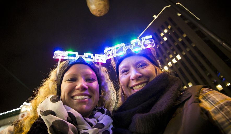 FILE--In this Dec. 31, 2014, file photo, Shelby Besler left, and her mother Tracey Besler, smile for a photograph on New Year's Eve as revelers ring in 2015 with the second annual Idaho Potato Drop in downtown Boise, Idaho. The Idaho Potato Commission has upped its sponsorship to $50,000 for the event, where a giant potato drops out of the sky as a countdown to the new year, that's now in its fifth year and keeps gaining more attention. (Darin Oswald/The Idaho Statesman via AP, file)