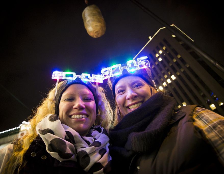 FILE--In this Dec. 31, 2014, file photo, Shelby Besler left, and her mother Tracey Besler, smile for a photograph on New Year's Eve as revelers ring in 2015 with the second annual Idaho Potato Drop in downtown Boise, Idaho. The Idaho Potato Commission has upped its sponsorship to $50,000 for the event, where a giant potato drops out of the sky as a countdown to the new year, that's now in its fifth year and keeps gaining more attention. (Darin Oswald/The Idaho Statesman via AP, file)