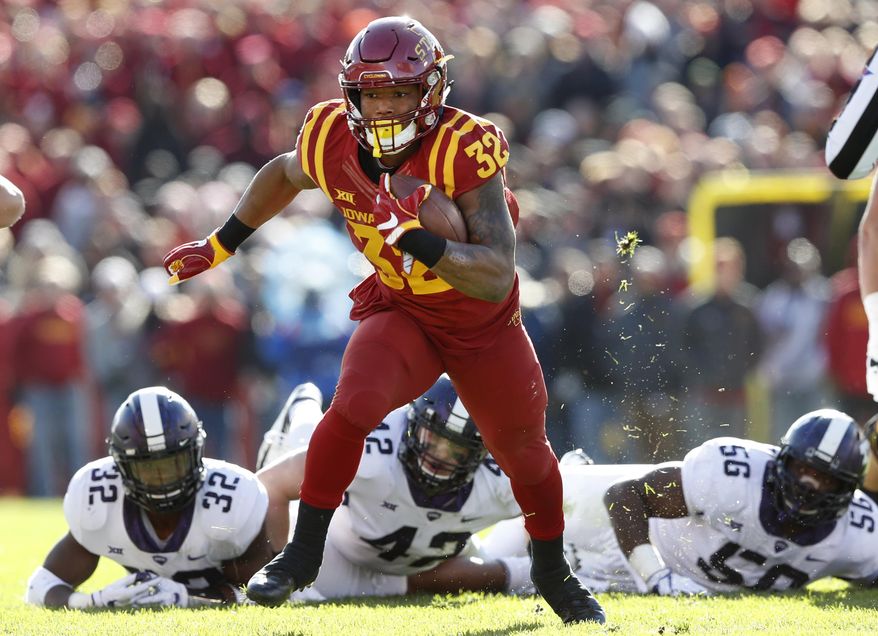 FILE - In this Oct. 28, 2017, file photo, Iowa State running back David Montgomery runs from TCU defenders Travin Howard (32), Ty Summers (42) and Chris Bradley (56) during the first half of an NCAA college football game, in Ames, Iowa. Montgomery leads the Big 12 with eight rushing touchdowns and is the second-leading rusher with 716 yards. Iowa State plays at West Virginia on Saturday, Nov. 4. (AP Photo/Charlie Neibergall, File)
