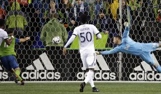 Vancouver Whitecaps goalie Stefan Marinovic, right, dives for a ball that crossed in front of the goal late in the first half of the second leg of an MLS soccer Western Conference semifinal against the Seattle Sounders, Thursday, Nov. 2, 2017, in Seattle. (AP Photo/Elaine Thompson)