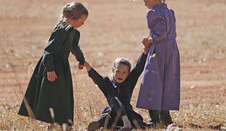 In this Wednesday, Oct. 25, 2017 photo, young girls play together in Colorado City, Ariz. The community on the Utah-Arizona border has been home for more than a century to a polygamous sect that is an offshoot of mainstream Mormonism. The community is undergoing a series of changes as the sect&#39;s control of the town slips away amid government evictions and crackdowns. (AP Photo/Rick Bowmer)