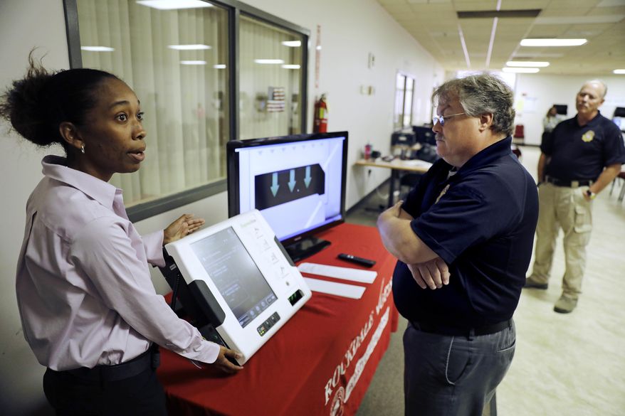 In this Thursday, Oct. 19, 2017 photo, Renee Phifer, Rockdale County board of elections assistant director, left, demonstrates a new voting machine at a polling site to Kelly Monroe, investigator with the Georgia secretary of state office in Conyers, Ga. Last summer, a security expert came across a gaping hole in Georgia&#39;s election management system. The revelation prompted a lawsuit seeking to compel Georgia to toss all of its touchscreen voting machines and replace them with a system that provides a paper record of every ballot cast. Georgia is one of five states where no such record exists. (AP Photo/David Goldman)
