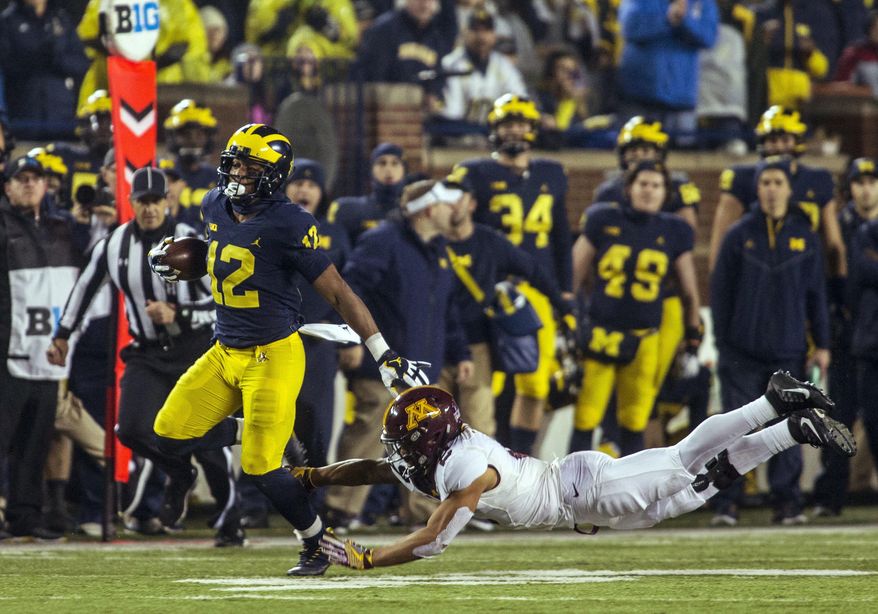 Michigan running back Chris Evans (12) rushes, avoiding a tackle from Minnesota defensive back Jacob Huff (2), in the second quarter of an NCAA college football game in Ann Arbor, Mich., Saturday, Nov. 4, 2017. (AP Photo/Tony Ding)