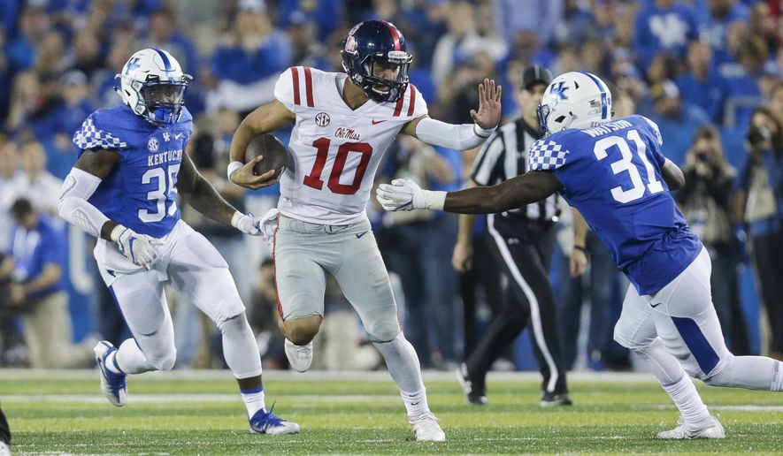 Mississippi quarterback Jordan Ta'amu (10) looks for room to run between Kentucky defensive end Denzil Ware, left, and linebacker Jamar Watson during the second half of an NCAA college football game Saturday, Nov. 4, 2017, in Lexington, Ky. (AP Photo/David Stephenson)