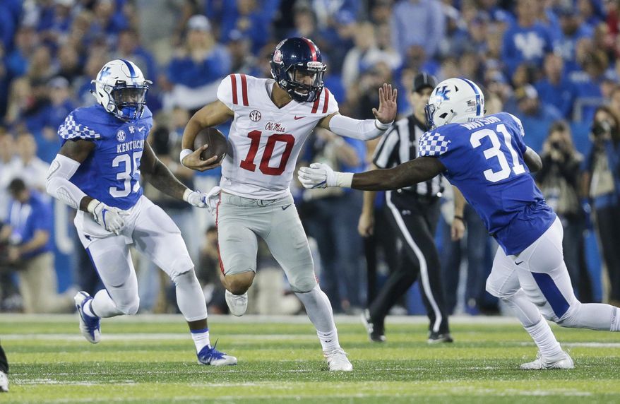 Mississippi quarterback Jordan Ta'amu (10) looks for room to run between Kentucky defensive end Denzil Ware, left, and linebacker Jamar Watson during the second half of an NCAA college football game Saturday, Nov. 4, 2017, in Lexington, Ky. (AP Photo/David Stephenson)