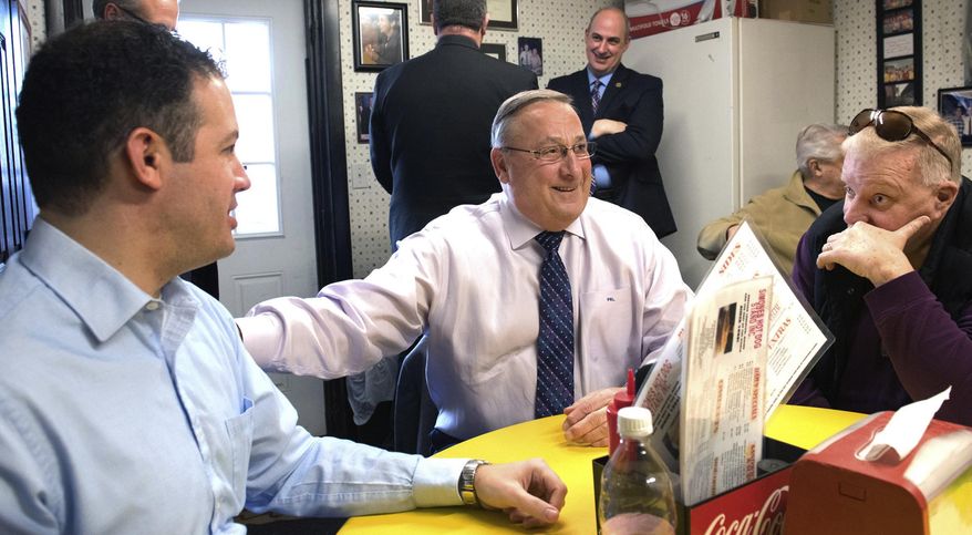In a Jan. 27, 2016 photo, Maine Gov. Paul LePage, center, makes a full-on sales pitch for consolidating Lewiston and Auburn into one city during a lunchtime meeting with the mayors of both cities, Auburn Mayor Jonathan LaBonte, left and Lewiston Mayor Robert Macdonald, at Simones' Hot Dog Stand in Lewiston, Maine. Residents will have the final say Tuesday, Nov. 7, 2017 on whether to combine the two former mill cities that are separated by the Androscoggin River. (Russ Dillingham/The Lewiston Sun-Journal via AP)