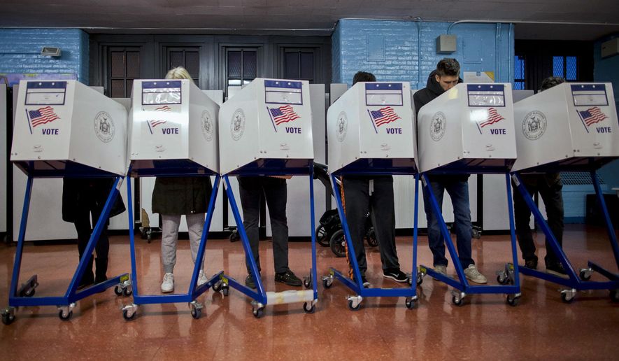 FILE--In this photo from Tuesday, Nov. 8, 2016, voters fill out their forms as they prepare to vote at a polling station in the Brooklyn borough of New York. New Yorkers will decide whether to call a constitutional convention and vote for mayor in New York City, Rochester, Buffalo and Syracuse Tuesday, Nov. 7, 2017. Voters will also cast ballots in several county races, and decide the fate of a constitutional amendment that would allow judges to strip the pensions of corrupt officials. Turnout for the off-year election is expected to be light. (AP Photo/Alexander F. Yuan, File)