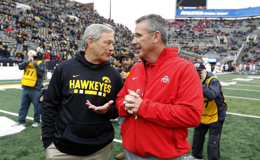 Iowa head coach Kirk Ferentz, left, talks with Ohio State head coach Urban Meyer before an NCAA college football game, Saturday, Nov. 4, 2017, in Iowa City, Iowa. (AP Photo/Charlie Neibergall)