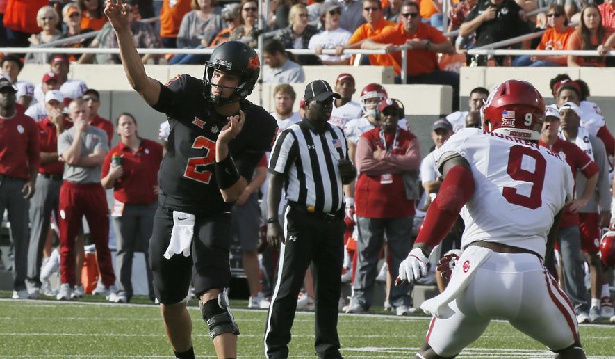Oklahoma State quarterback Mason Rudolph (2) passes in front of Oklahoma linebacker Kenneth Murray (9) in the first half of an NCAA college football game in Stillwater, Okla., Saturday, Nov. 4, 2017. (AP Photo/Sue Ogrocki)